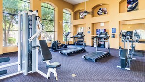 A gym with various exercise equipment, large windows, and a ceiling fan. - KING Beds, Heated Community Pool! 3 miles from Cardinal Stadium! (Phoenix)