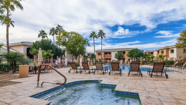 A pool area with lounge chairs and a small pool. - KING Beds, Heated Community Pool! 3 miles from Cardinal Stadium! (Phoenix)