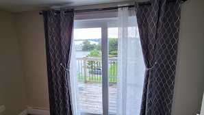 A room with a sliding glass door leading to an outdoor deck. - Coastal Charm by the Bay: 4 Bedroom Apartment next to Yarmouth CAT Ferry (Yarmouth)