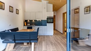 Eine moderne Küche mit weißen Schränken, einer schwarzen Arbeitsplatte und einem eingebauten Backofen.