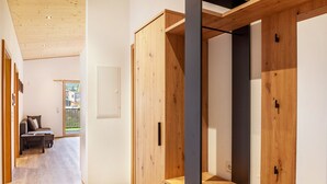Ein modernes Interieur mit Holzschränken, einer Couch und Blick ins Freie.