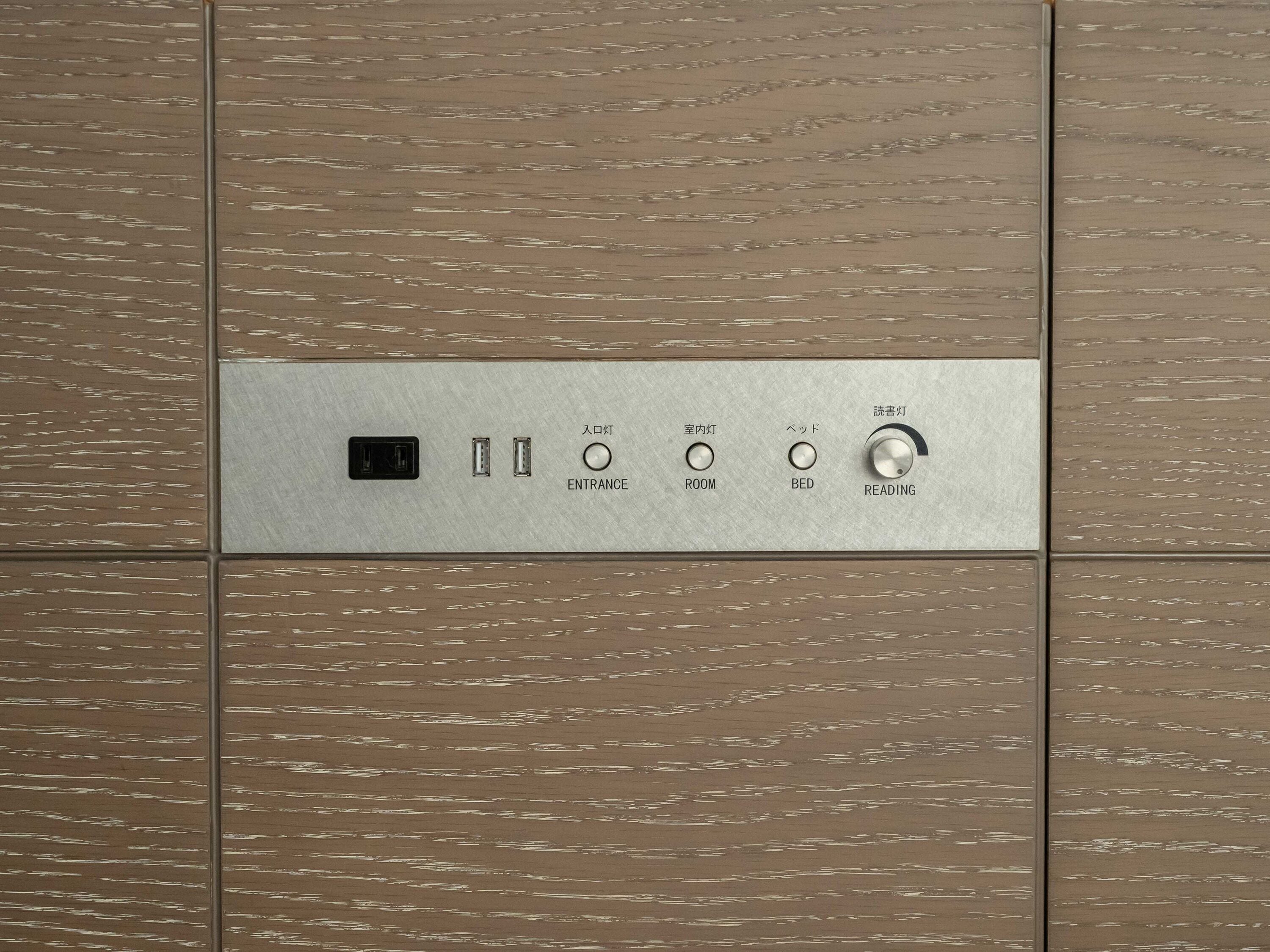 Un panel de control con botones etiquetados para entrada, habitación, cama y lectura.