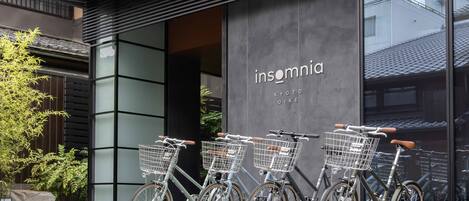 Fachada con los nombres "insomnia" y "KYOTO OIKE" a la vista. Hay bicicletas con cestas estacionadas al frente.