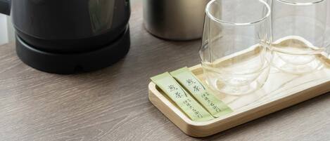A coffee maker, a pot with ice, and two glasses on a wooden tray.
