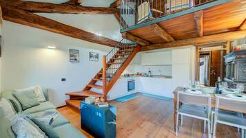 Un vaste espace de vie agrémenté d’un escalier en bois, d’une table à manger dressée et d’un canapé confortable.