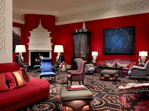 A red-themed living room with a fireplace, patterned carpet, and various seating options. - 2 Affordable Rooms! Pet-Friendly, Near Oregon Zoo (Portland)