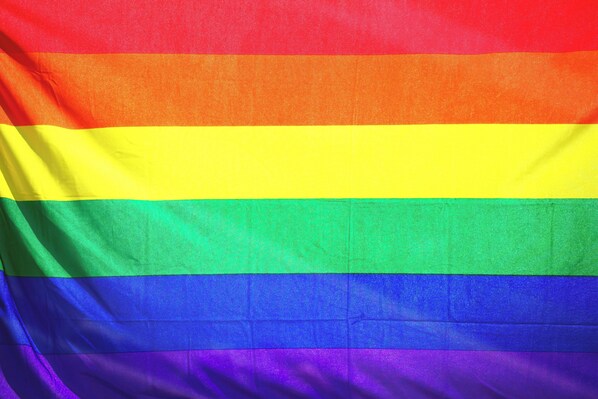 A flag with horizontal stripes of red, orange, yellow, green, blue, and purple.