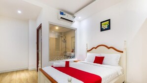 A bedroom with a bed, a window, a door, and an air conditioning unit. - Spring Airport Hotel (Ho Chi Minh City)
