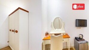 A room with a white wardrobe, a wooden desk with a mirror, a small fridge, and a television on the wall. - Spring Airport Hotel (Ho Chi Minh City)