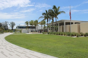 A modern building with a flat roof, surrounded by a well-maintained lawn and palm trees. - Tasteful Home, Big Yard, Central, 2 miles to Beach (Sarasota)