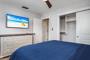 A bedroom with a bed, a dresser, a closet, and a painting of a beach scene. - Tasteful Home, Big Yard, Central, 2 miles to Beach (Sarasota)