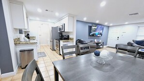 A modern kitchen with white cabinets, a built-in microwave, and a stainless steel refrigerator. - 3BR retreat w/ private fence yard • 16 min to Siesta Key (Sarasota)