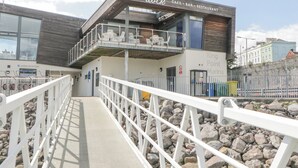 A modern building with a cafe, bar, and restaurant. It has a marina reception area and a King Point Marina sign. - The Penthouse, Phoenix Quay (Plymouth)