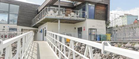 A modern building with a cafe, bar, and restaurant. It has a marina reception area and a King Point Marina sign.