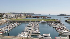 A marina with numerous boats docked, a pier, and buildings in the background. - The Penthouse, Phoenix Quay (Plymouth)