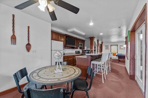 Enjoy a spacious living area with a kitchen, dining space, and pool table.