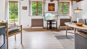 A cozy living room with a wooden ceiling, a fireplace, a television, and a dining area. - "Rina" - 250m from the sea by Interhome (Hasle)