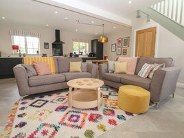 A modern living room with a grey sofa, a round coffee table, and a colorful rug.