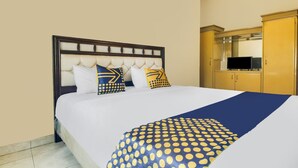 A hotel room with a large bed, a wooden headboard, and a wardrobe. - SPOT ON 91620 Skypiea Guest House (Tasikmalaya)