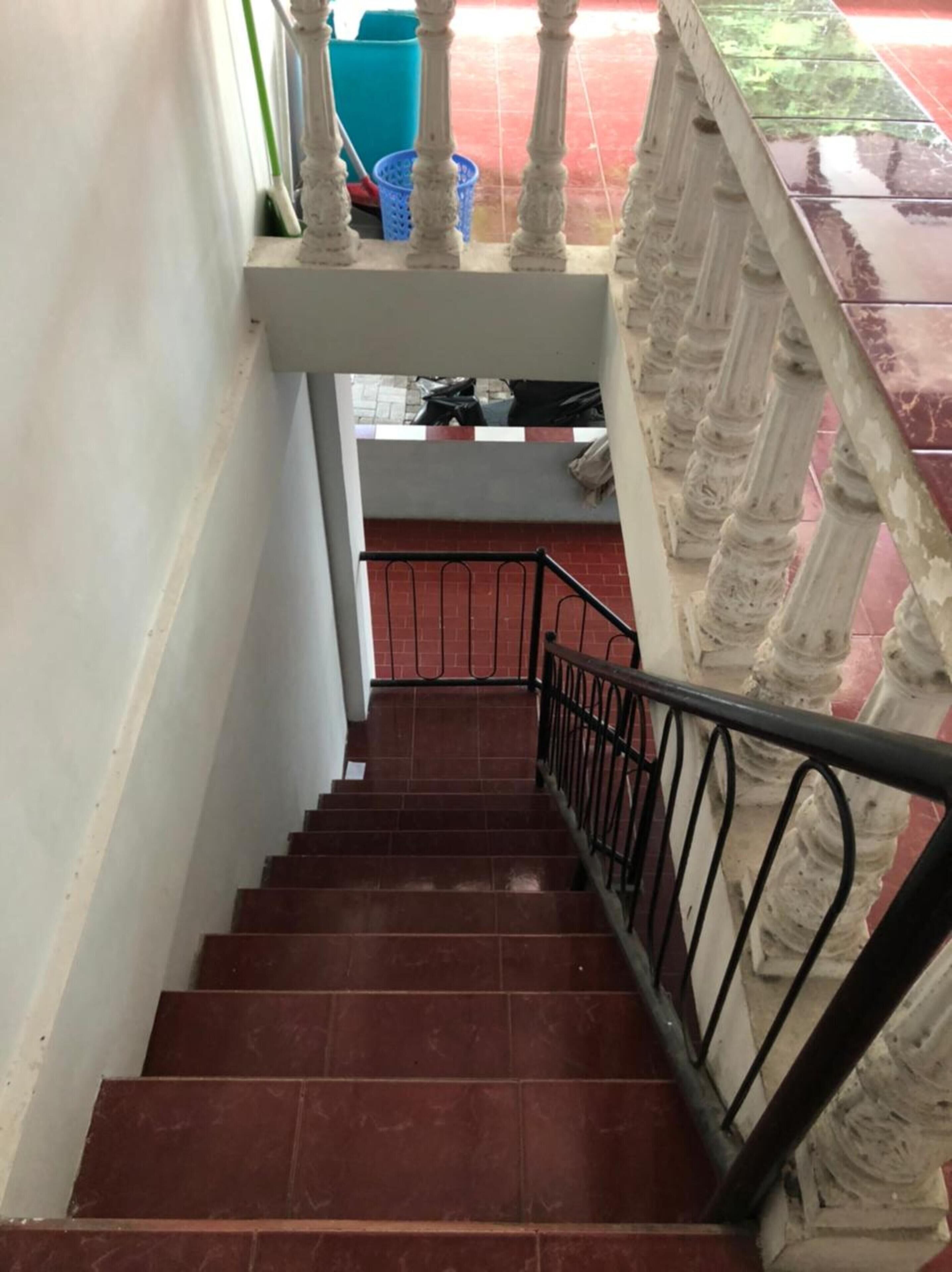 A staircase with a metal railing and a balustrade, leading to a lower level.