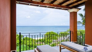 A balcony with a view of the ocean, a wooden bench, and a lounge chair with a towel. - Newly Renovated, Beachfront, 3 bed Condo on Exclusive Langosta Beach! (Tamarindo)
