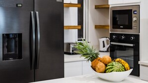 A kitchen with a stainless steel refrigerator, microwave, and oven. - Newly Renovated, Beachfront, 3 bed Condo on Exclusive Langosta Beach! (Tamarindo)