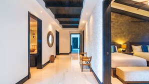 A modern hotel room with a large bed, a seating area with a bench, and a view of the hallway. - Beautiful 3 Bedroom Condo (Punta de Mita)