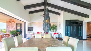 A spacious living area with a large dining table, comfortable seating, and a modern ceiling design. - Beautiful 3 Bedroom Condo (Punta de Mita)