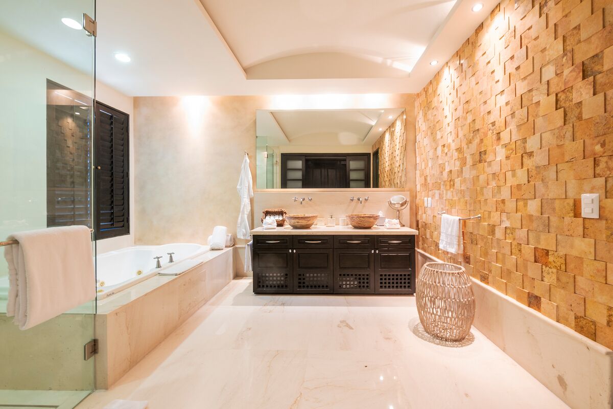 A modern bathroom with a large bathtub, a glass shower enclosure, and a tiled wall.