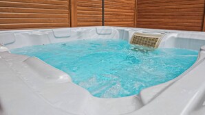 Una vasca idromassaggio con acqua cristallina, circondata da pannelli in legno.