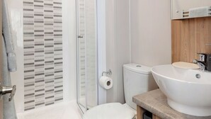 Un bagno moderno con doccia, servizi igienici e lavandino.