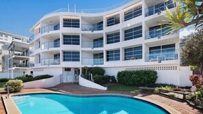 A multi-story building with a swimming pool in front. - Pumicestone Chase 5 Absolute Water Front (BULCOCK BEACH)