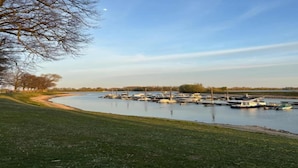 Una marina con imbarcazioni ormeggiate lungo la riva del fiume.