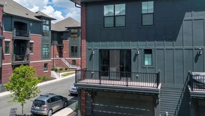 Un immeuble résidentiel moderne à plusieurs étages, doté d’un toit plat, de grandes fenêtres et d’un porche avant couvert.