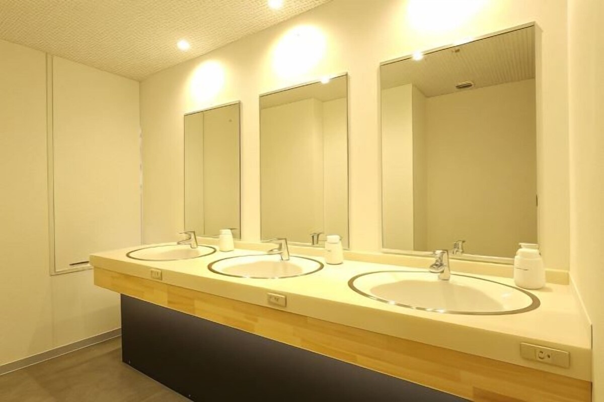 Un baño moderno con dos lavamanos, espejos y un mueble de tocador de madera.