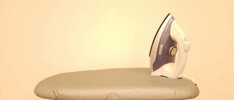 An ironing board with a folded iron on top.