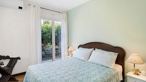 A bedroom with a bed, a nightstand, a lamp, and a window with curtains. - Holiday Apartment "Villa Isabella Casa Lucia" with Sea View, Shared Terrace & Wi-Fi (Imperia)