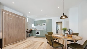 A modern kitchen with a dining area, wooden cabinets, and a central island.