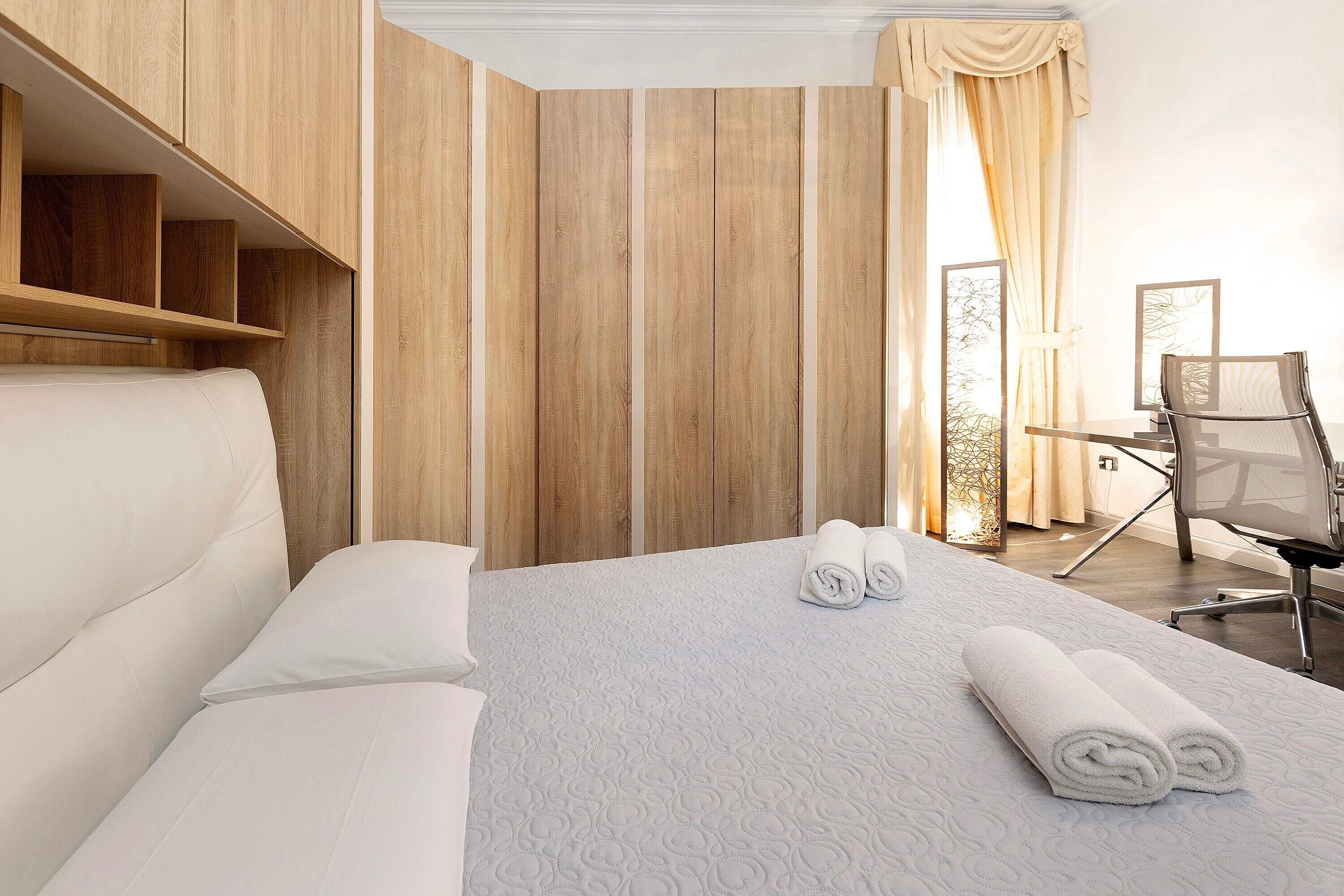 Ein Hotelzimmer mit Bett, Stuhl und Schreibtisch.