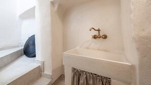 Ein Badezimmer mit einer weißen Badewanne, einem Messingarmaturen und einem Karomuster-Vorhang.