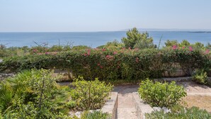 A garden with a view of the sea, stone steps, and various plants. - Apartment "Kind of Blue" with Sea View, Wi-Fi and Air Conditioning (Siracusa)