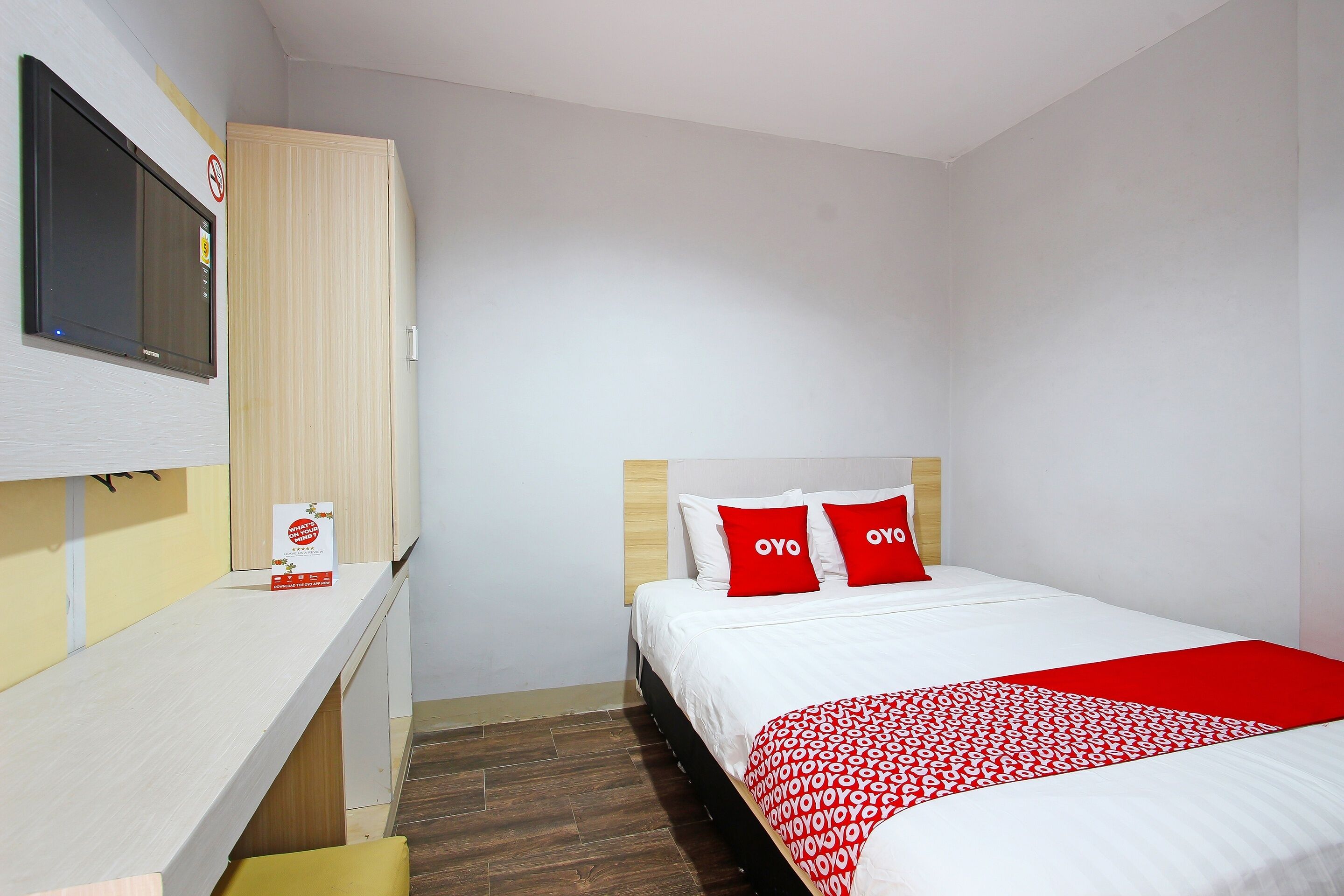 Una habitación de hotel con una cama, un escritorio y un televisor.