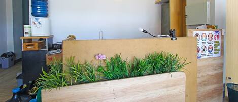 Una reception con un distributore d'acqua, una sveglia e una bacheca con avvisi sulla salute e sicurezza.