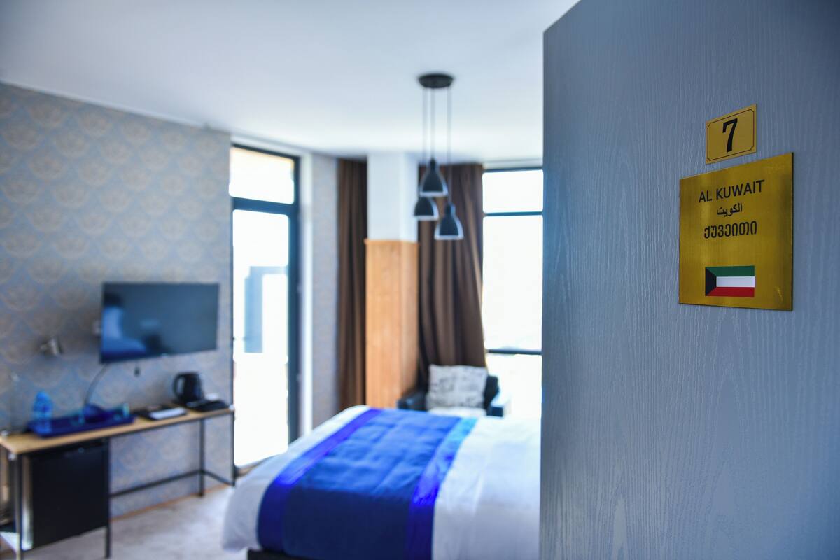 Une chambre d’hôtel équipée d’un lit, d’un bureau, d’une télévision et d’une pancarte indiquant le numéro de chambre : 7.