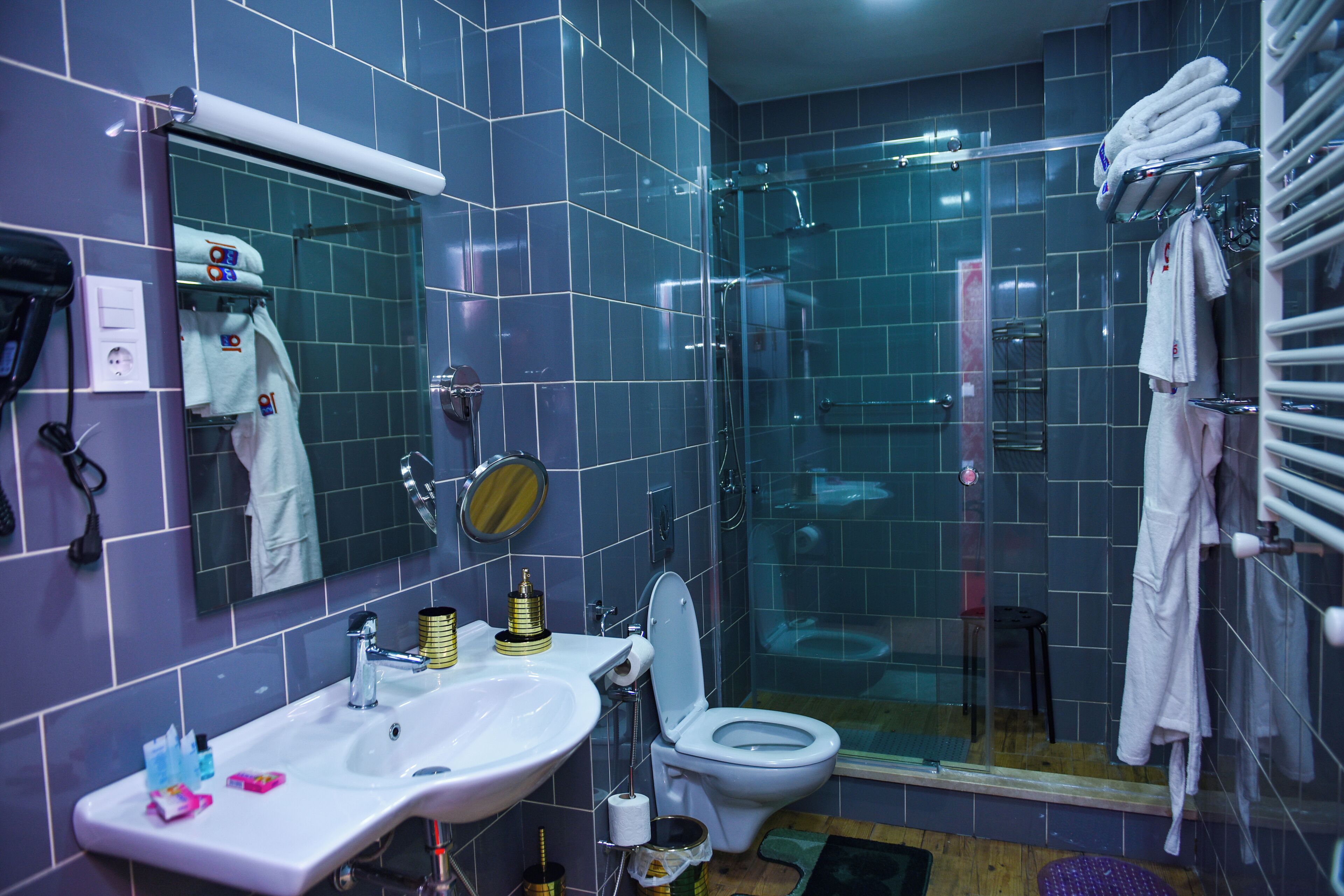 A bathroom with a sink, toilet, and glass shower enclosure.
