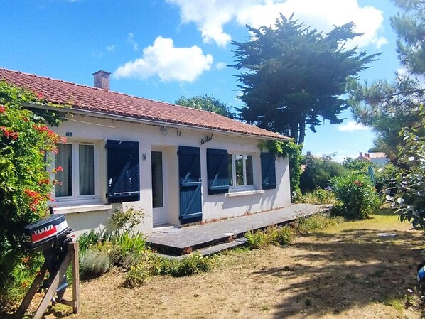 Guests can enjoy a peaceful retreat surrounded by lush vegetation and a charming front porch.
