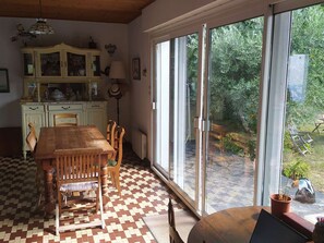 Enjoy meals with family and friends at the large dining table, surrounded by a beautiful garden view.