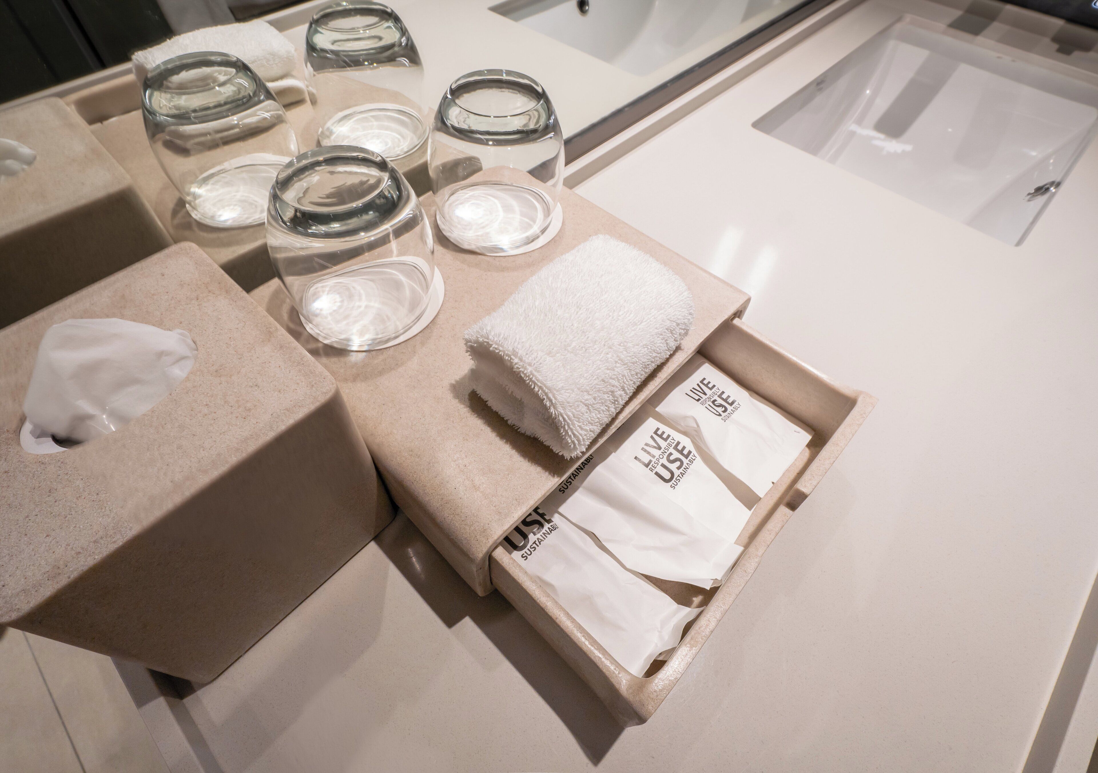 A display of glassware and towels in a box, with a visible label reading "LIVE USE".