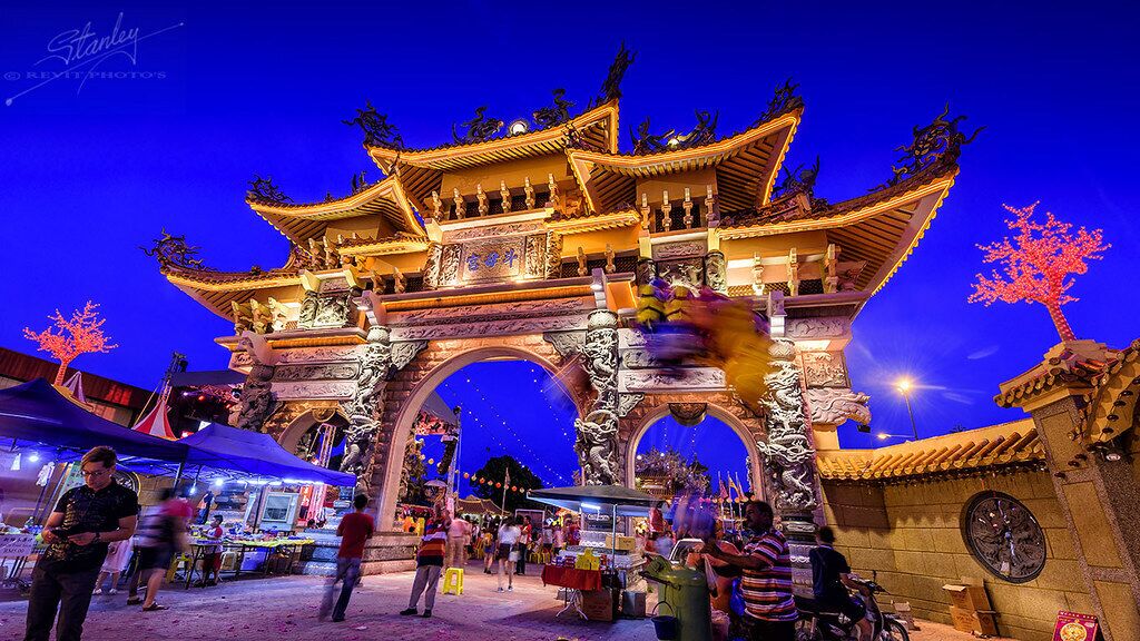 A traditional Chinese gate with intricate carvings and a large circular window.
