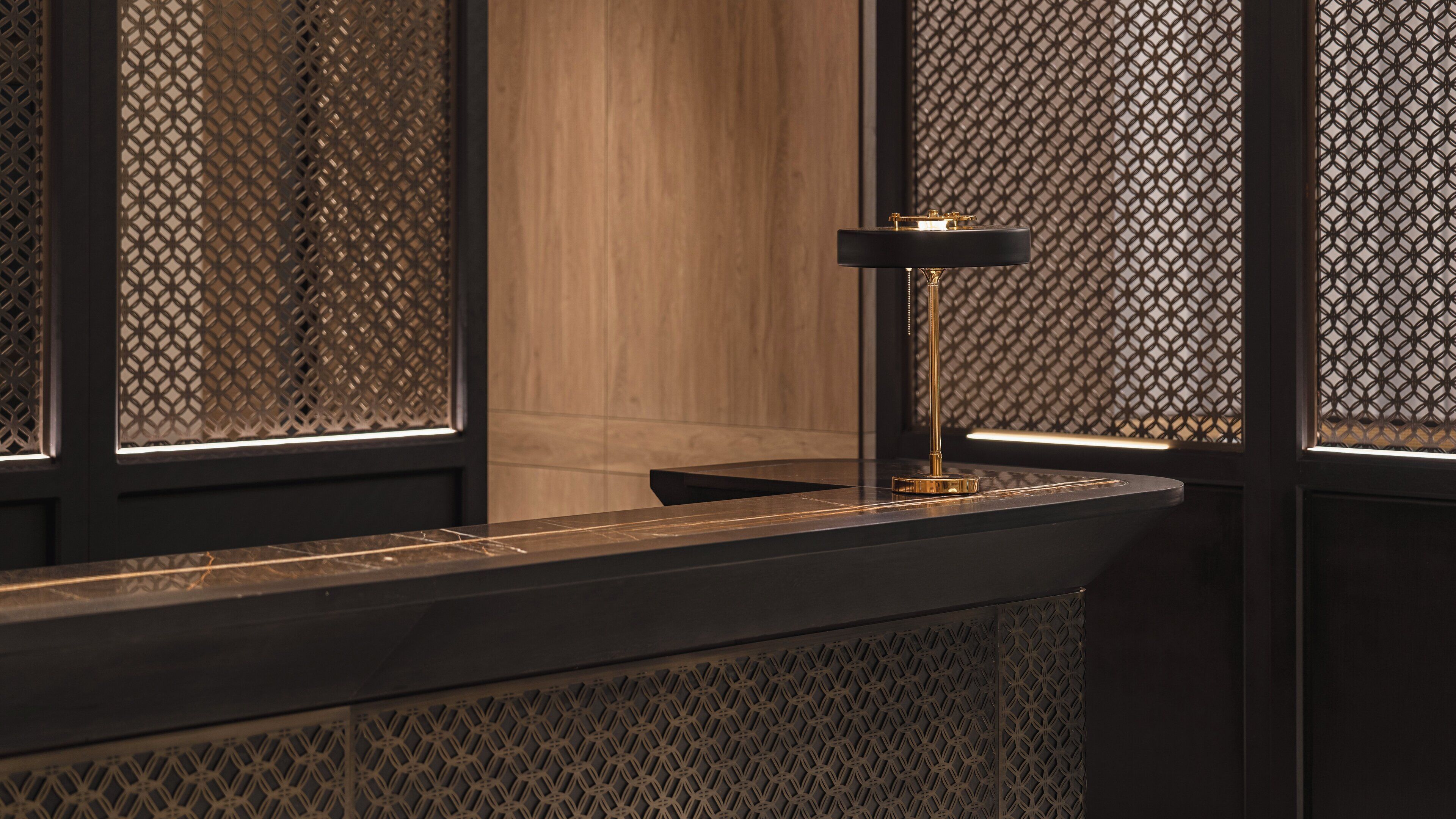 A modern interior with a wooden panel wall, a black-framed window, and a gold-colored floor lamp.